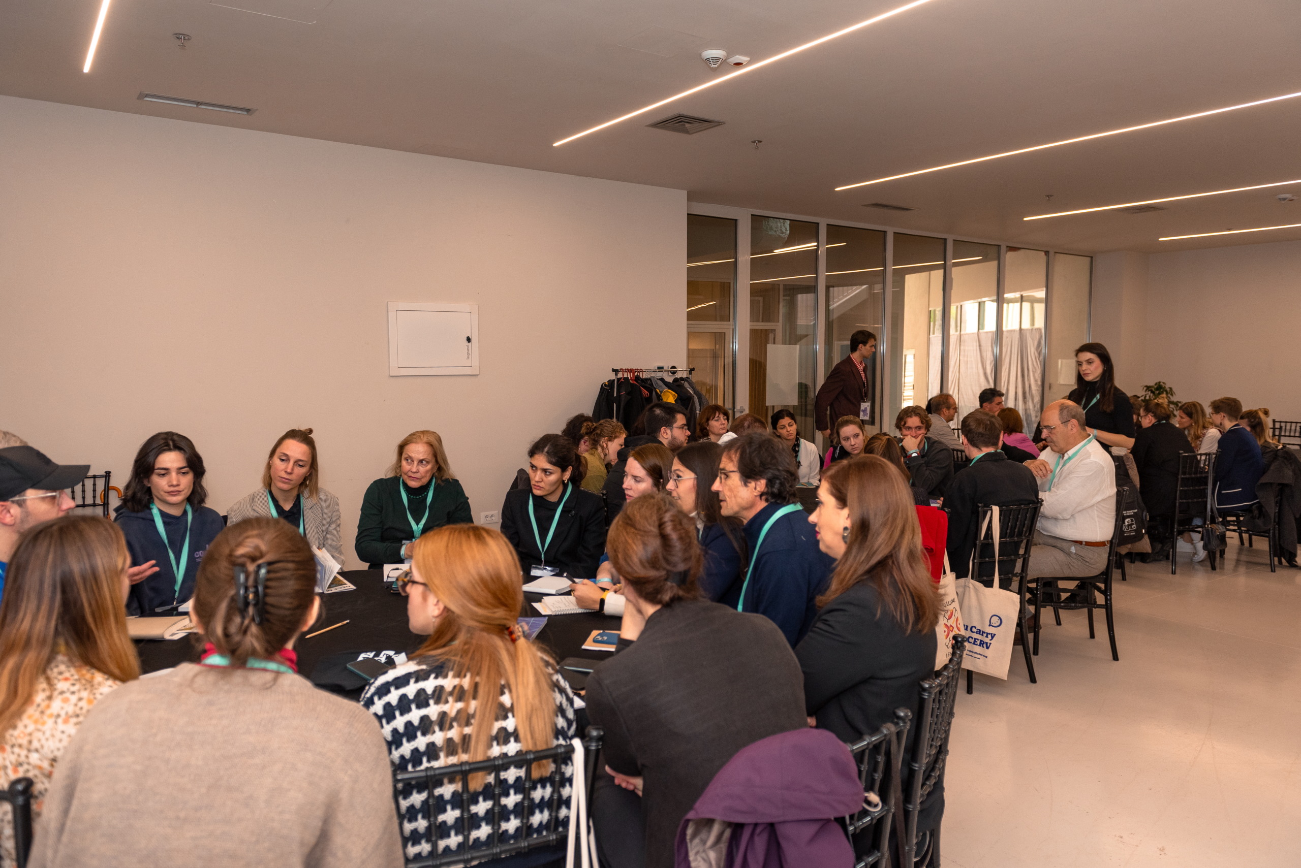 © THE CIVICS Innovation Hub | Geri Lula A diverse group of people engaged in discussion around tables during NECE Festival 2024.