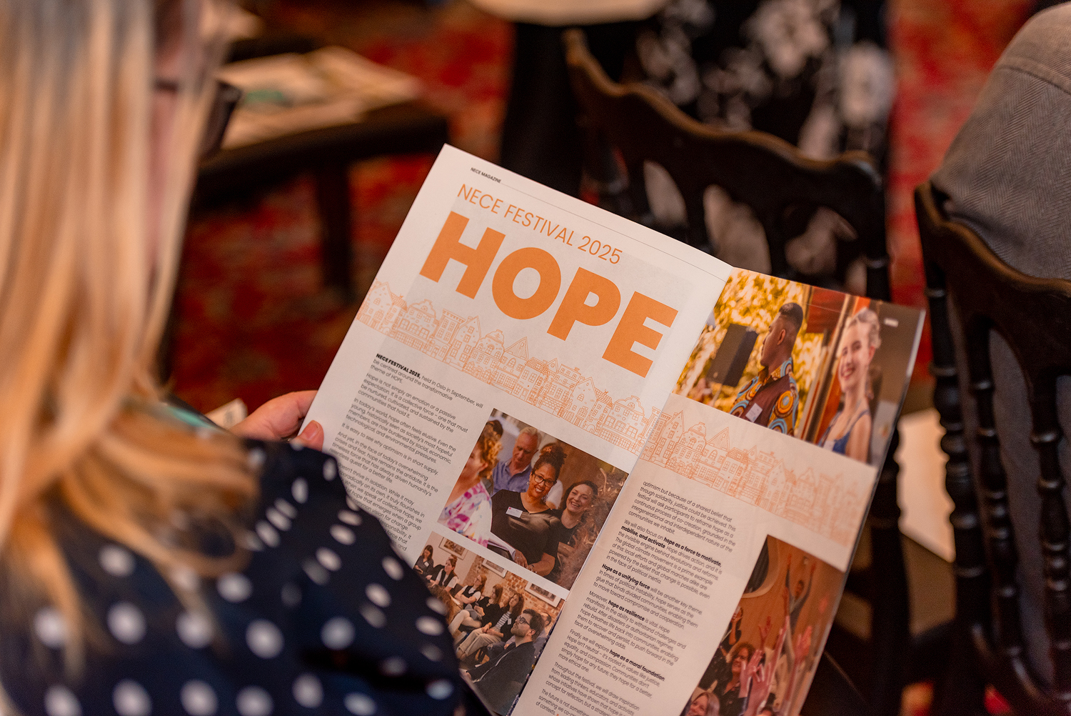 The picture shows a NECE Festival participant reading the NECE Magazine: BORDERS.