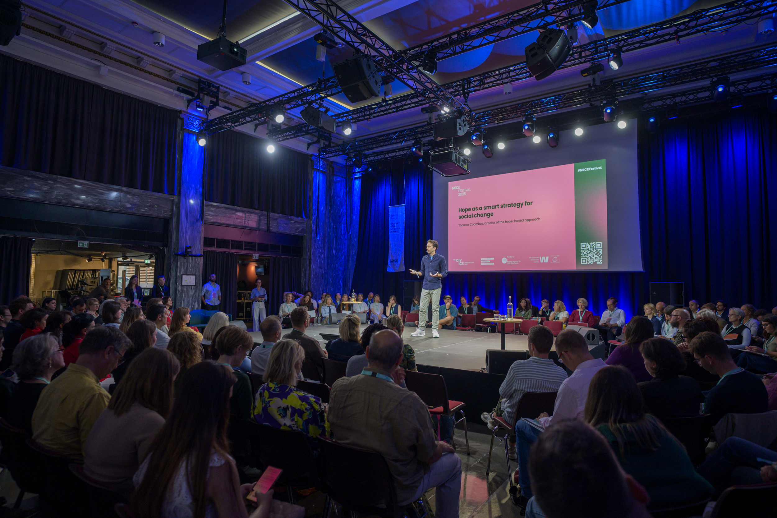 © THE CIVICS Innovation Hub / Werner Anderson Thomas Coombes giving a talk on stage during NECE Festival: HOPE.