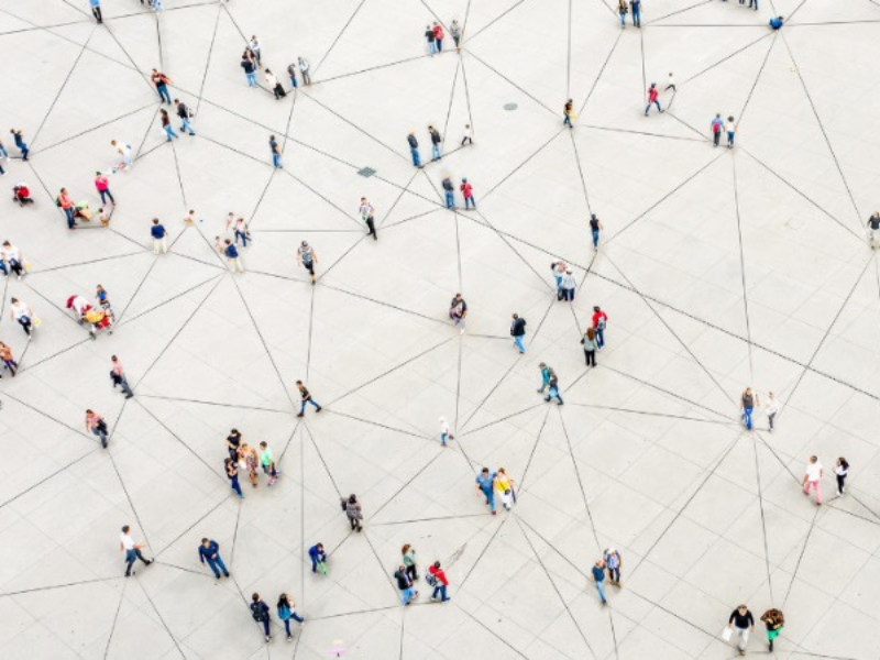 The image shows people from above, standing alone or in small groups forming a network, visualizes by black lines.